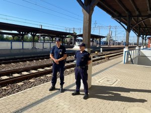 peron kolejowy, policjant i funkcjonariusz Służby Ochrony Kolei stoją przy torach