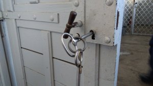 drzwi z kluczem w zamku do pomieszczenia dla osób zatrzymanych