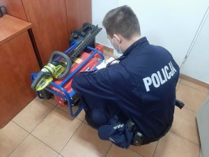 Policjant wykonujący czynności z odzyskanym mieniem