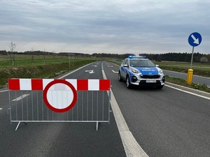radiowóz stoi na drodze, obok znak zakaz wjazdu
