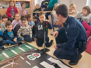 klasa, policjant pokazuje dzieciom sygnalizator świetlny