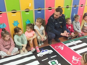 policjant znajduję się przed matą edukacyjną wraz z dziećmi