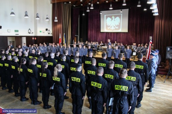 policjanci ubrani w mundur czarne moro stoją zgromadzeni w sali i składają ślubowanie