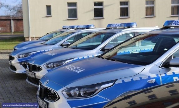 cztery radiowozy zaparkowane przed budynkiem