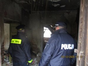 Funkcjonariusze stoją wewnątrz opuszczonego budynku