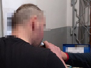 zdjęcie przedstawia mężczyznę, który dmucha w ustnik alkomatu