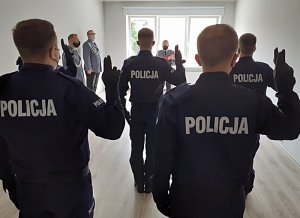 policjanci stoją z uniesioną prawą ręką w geście ślubowania